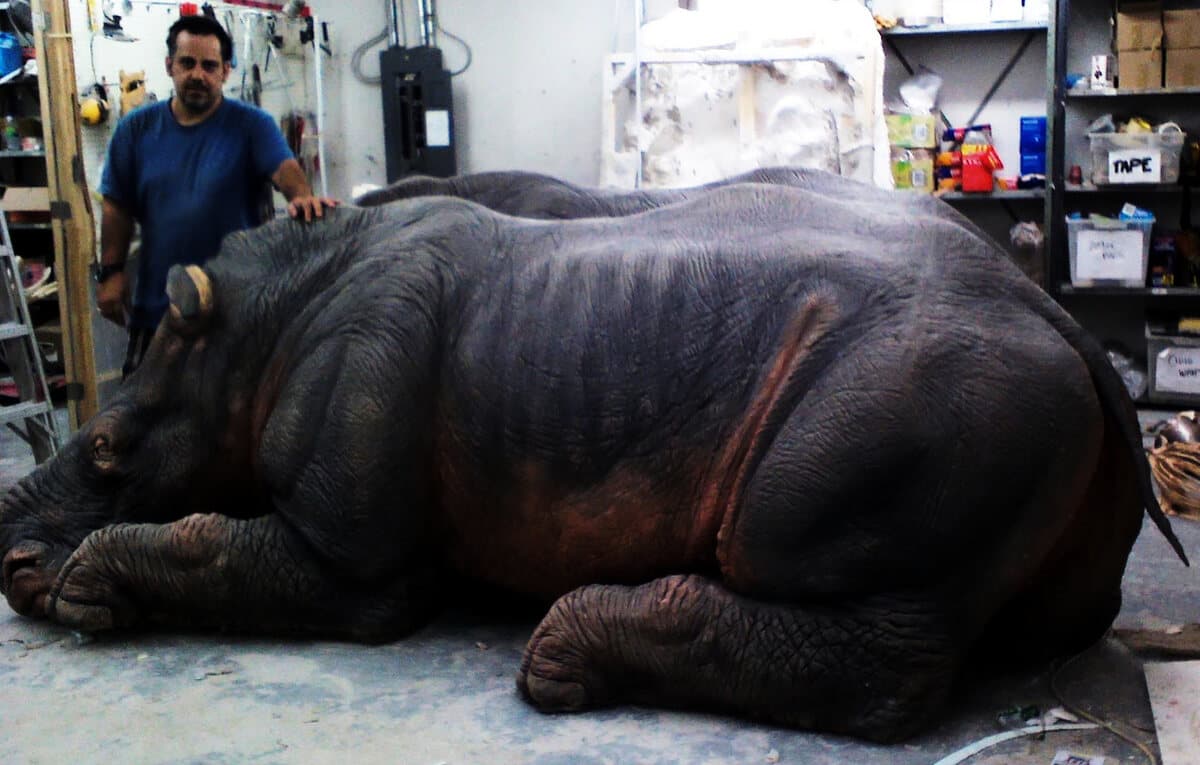 Nikos beside a full-scale sculpted rhinoceros in the workshop